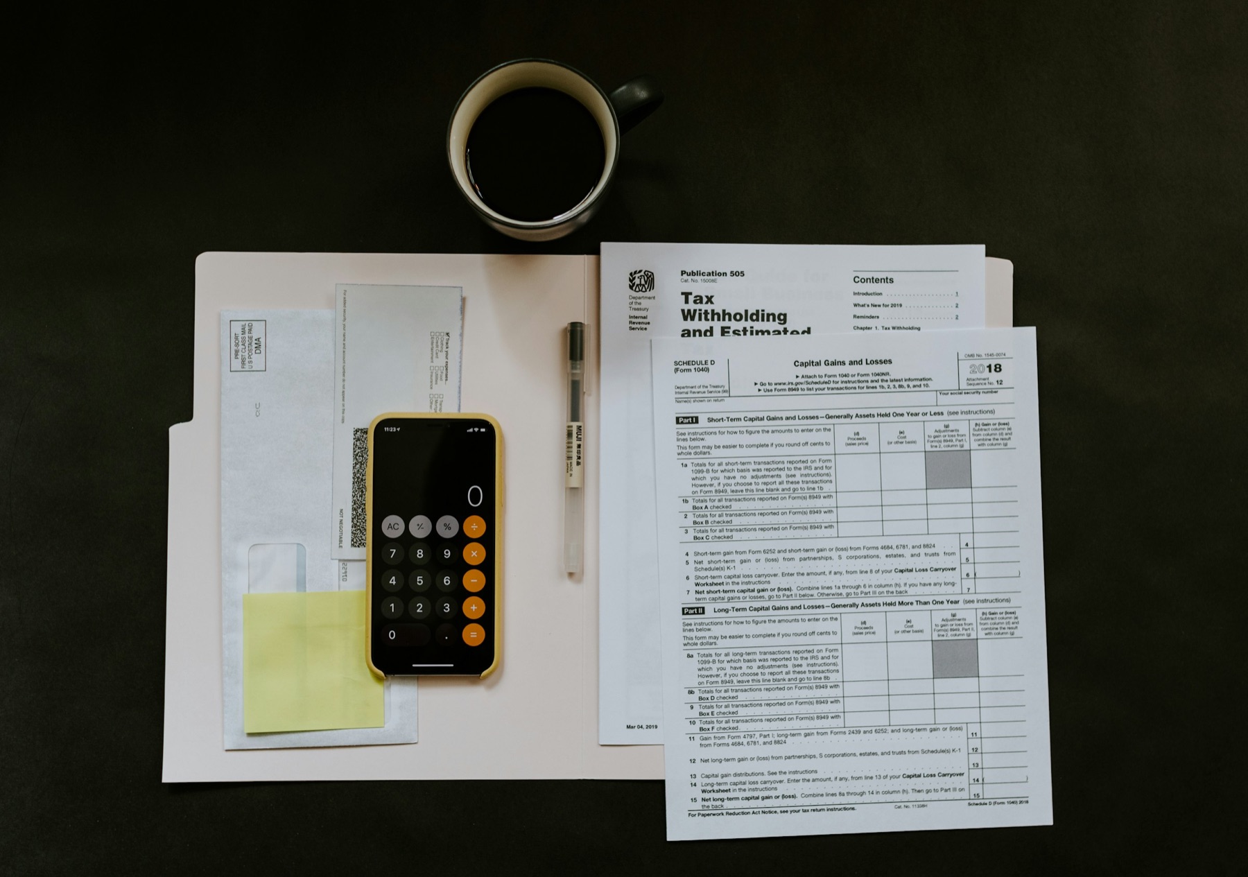 Tax certificate, pen and smartphone on a desk in preparation for the end of the financial year.